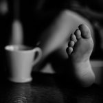 grayscale photo of person holding mug